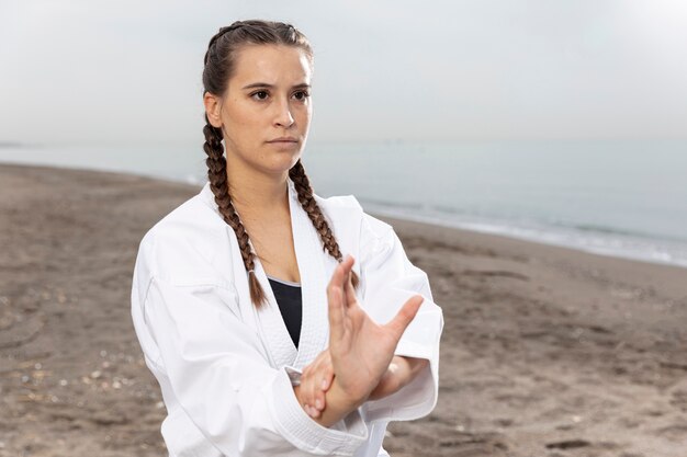 Joven modelo en traje de karate al aire libre