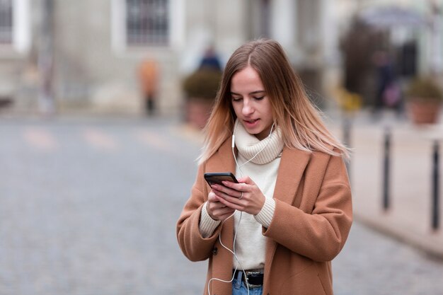 Joven moderna escuchando música en auriculares