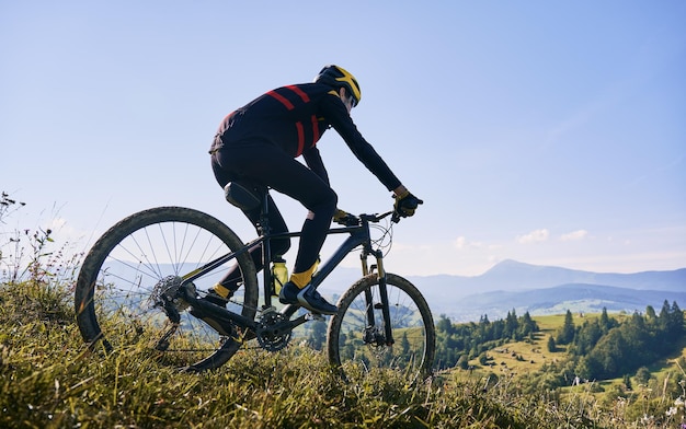 Joven montando una bicicleta de montaña al estilo cuesta abajo