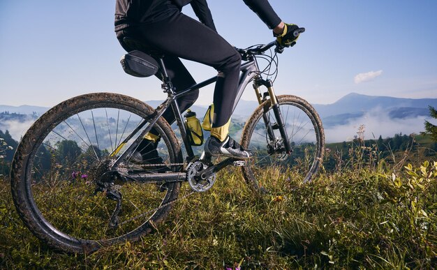 Joven montando una bicicleta de montaña al estilo cuesta abajo