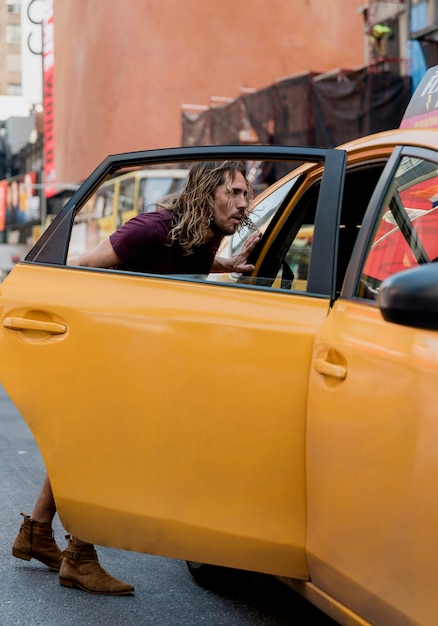 Joven montando taxi en la ciudad