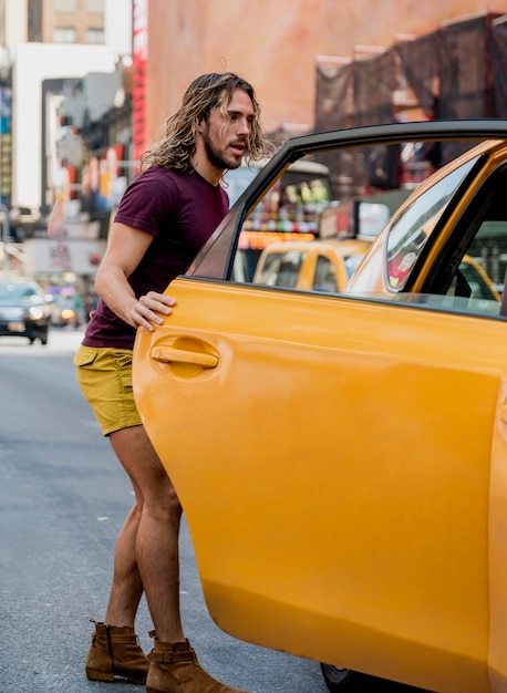 Joven montando taxi en la ciudad