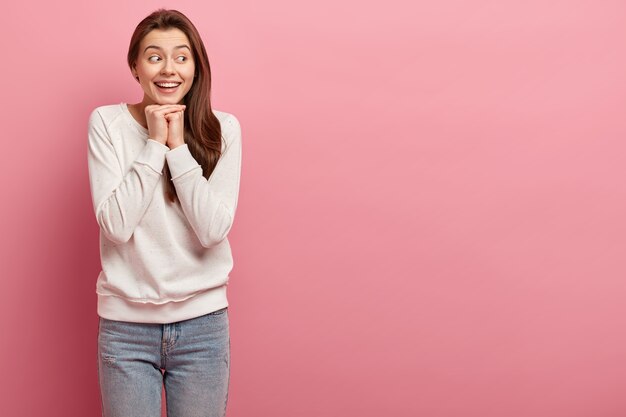 Joven morena en jeans y suéter