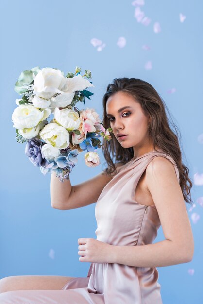 Joven morena sensual con una bella composición de flores.