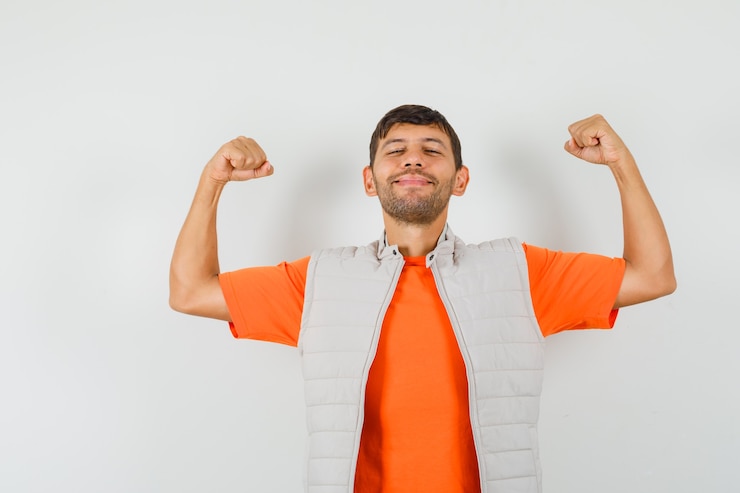 Foto gratuito joven mostrando gesto de éxito en camiseta, chaqueta y mirando feliz