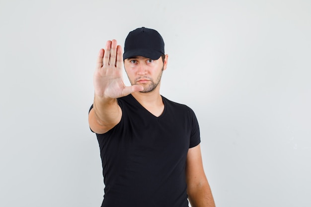 Joven mostrando gesto de parada en camiseta negra