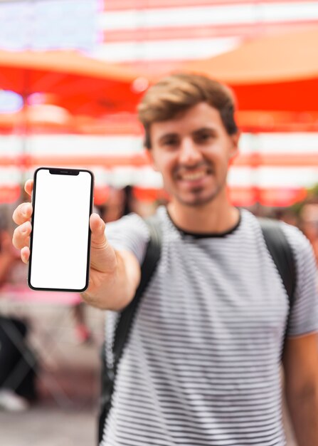 Joven mostrando una pantalla de teléfono inteligente