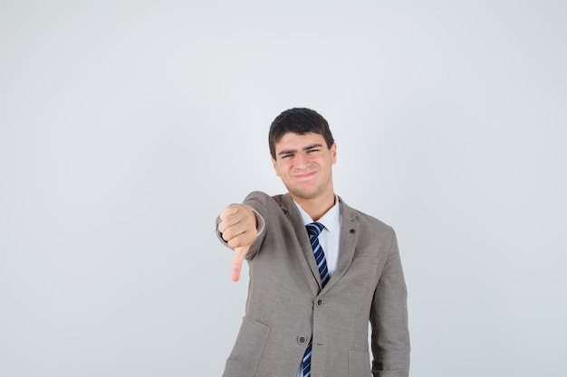 Joven mostrando el pulgar hacia abajo en traje formal