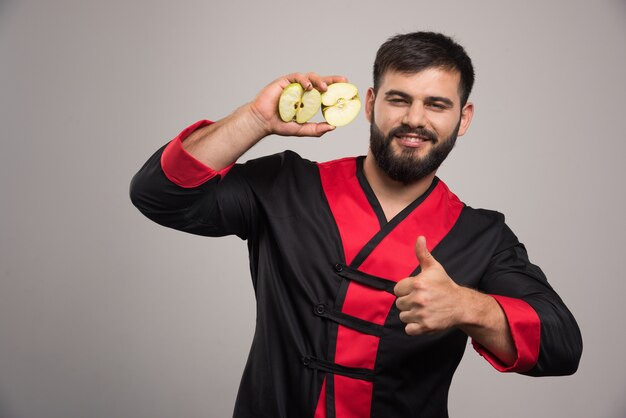 Joven mostrando rodajas de manzana fresca.