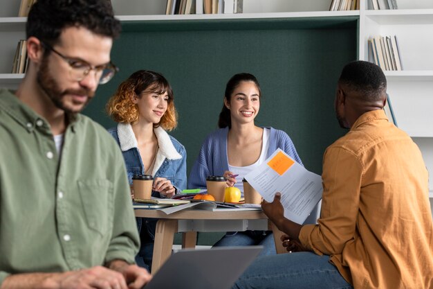 Joven mostrando a sus amigos sus notas durante la sesión de estudio