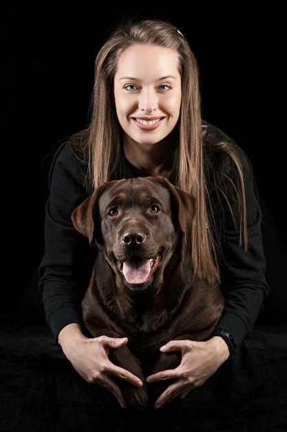 Foto gratuita la joven mujer abrazando a un perro de raza mix