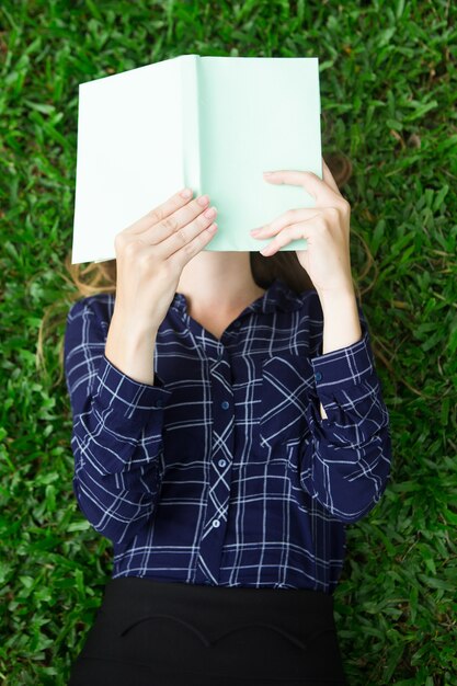 Joven, mujer, acostado, hierba, lectura, libro