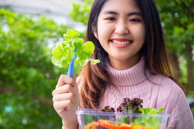 Joven mujer adolescente con ensalada de vegetales