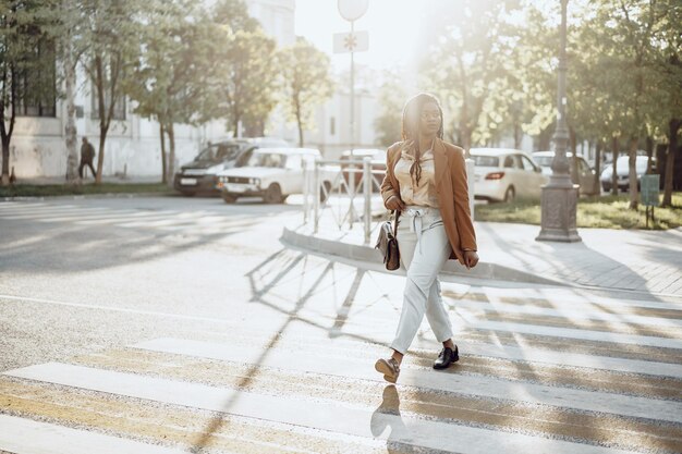 Joven, mujer americana africana, cruzar la calle