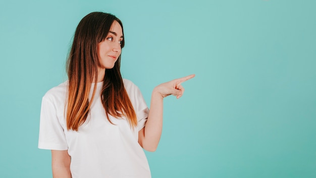 Foto gratuita joven mujer apuntando a la derecha