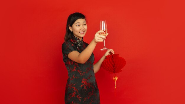 Joven mujer asiática bebiendo champán y sosteniendo la linterna