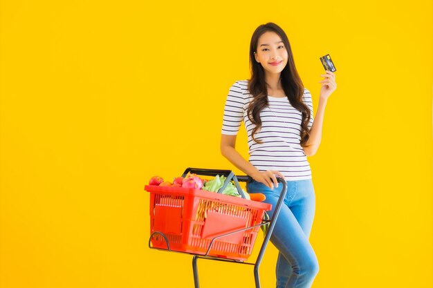 joven mujer asiática compras carrito de supermercado