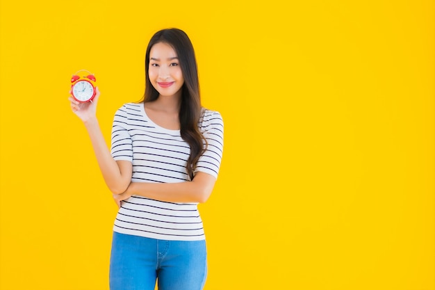 joven mujer asiática mostrar reloj o alarma