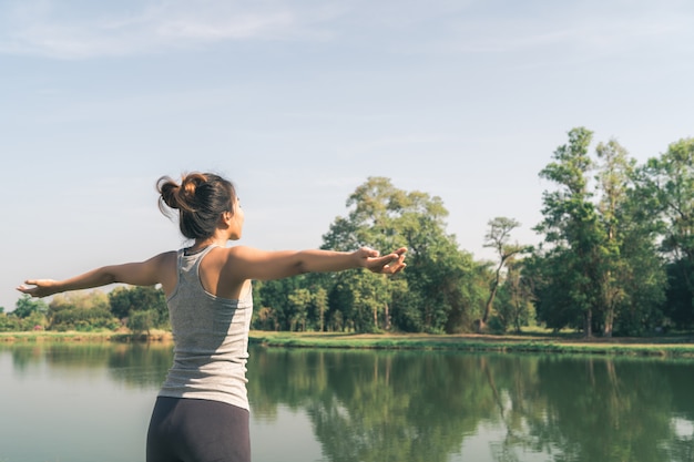 Foto gratuita joven mujer asiática de yoga al aire libre mantiene la calma y medita mientras practica yoga