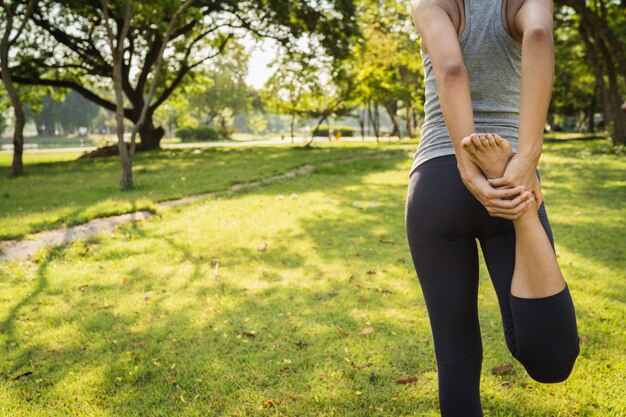 Joven mujer asiática de yoga al aire libre mantiene la calma y medita mientras practica yoga