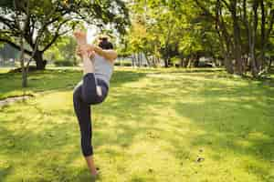 Foto gratuita joven mujer asiática de yoga al aire libre mantiene la calma y medita mientras practica yoga