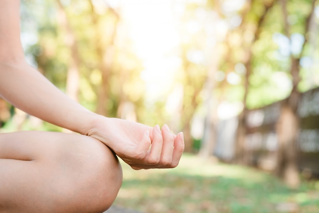 Joven mujer asiática de yoga al aire libre mantiene la calma y medita mientras practica yoga