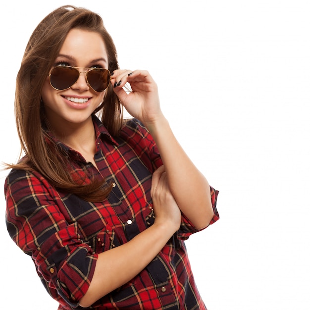 Joven mujer atractiva en camisa y gafas de sol