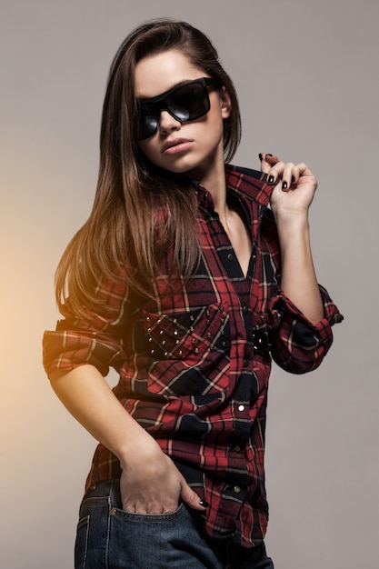 Joven mujer atractiva en camisa y gafas de sol