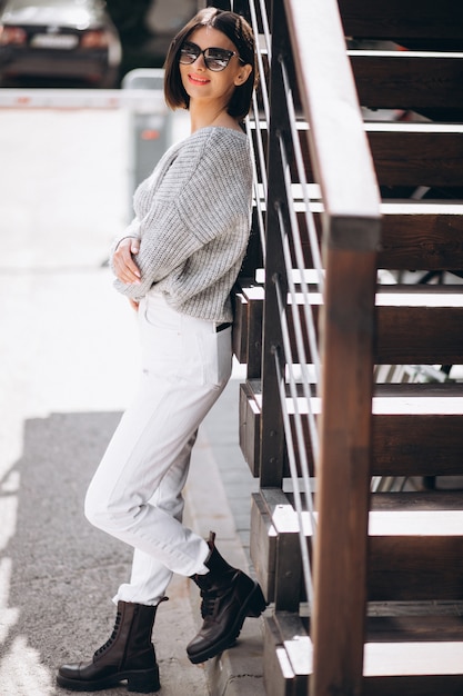 Foto gratuita joven mujer atractiva en jeans blancos fuera de la calle