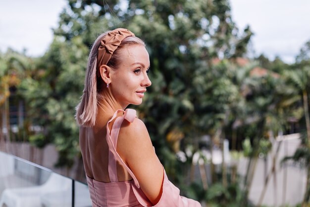 Joven mujer bonita caucásica sola en vestido lindo de verano de vacaciones en villa de lujo