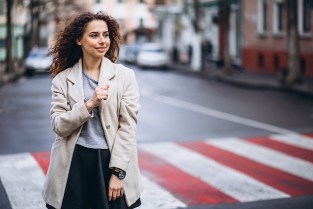 Joven mujer bonita en un cruce de peatones