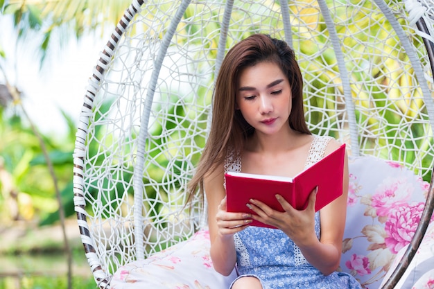 Foto gratuita joven mujer bonita con diario rojo en el parque