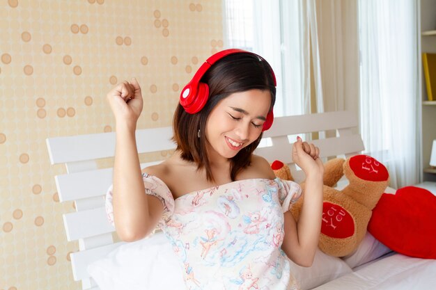 Joven mujer bonita escuchando canción con auriculares