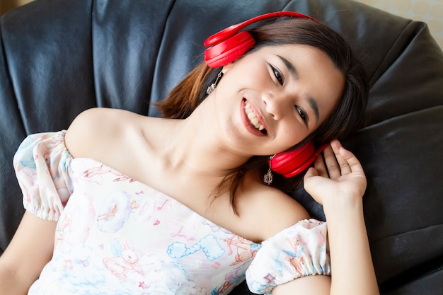 Joven mujer bonita escuchando canción con auriculares