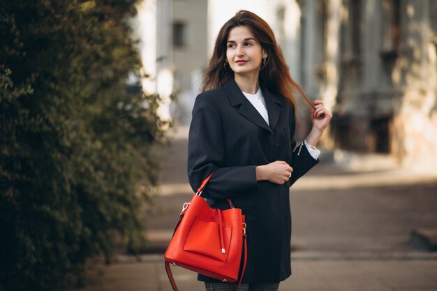 Joven mujer bonita en traje elegante en una calle de otoño