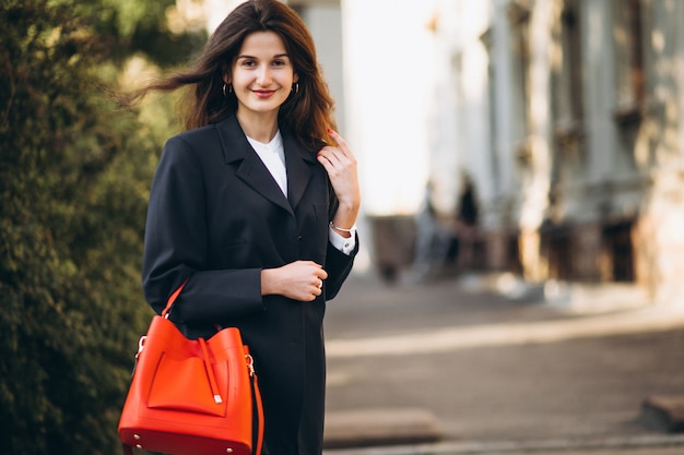 Joven mujer bonita en traje elegante en una calle de otoño