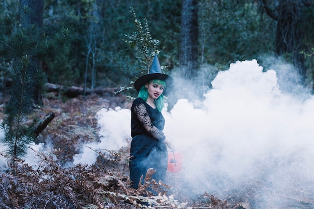 Joven mujer bruja en el humo