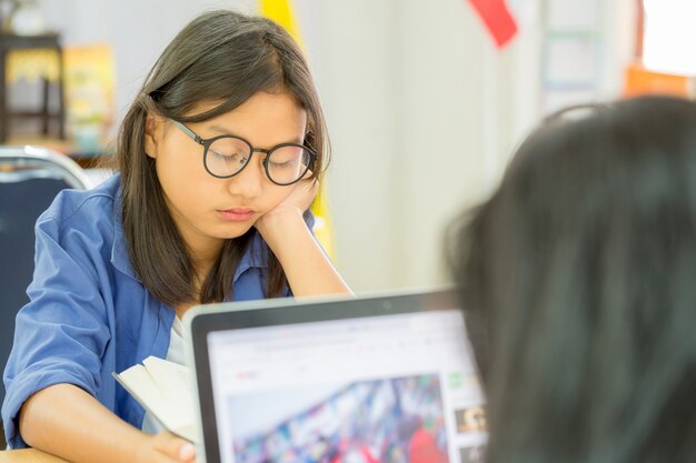 Joven mujer de cabello castaño en gafas leer libro