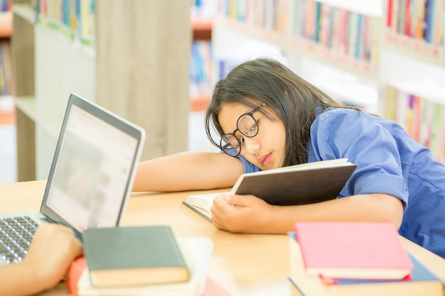 Joven mujer de cabello castaño en gafas leer libro