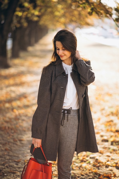 Joven mujer caminando en un parque de otoño