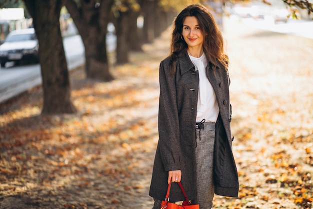 Joven mujer caminando en un parque de otoño