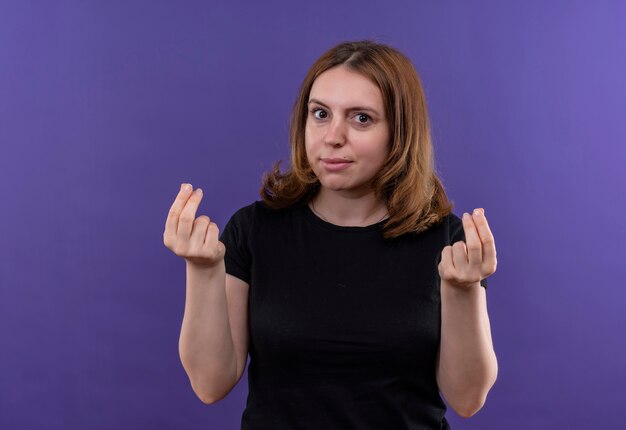 Joven mujer casual haciendo gesto de dinero en la pared púrpura aislada con espacio de copia