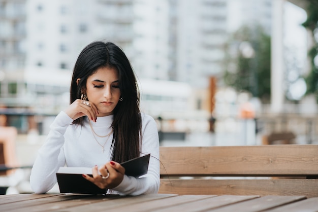 Joven mujer caucásica trabajando con un portátil en el café