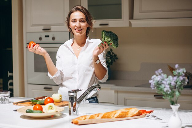 Joven mujer cocinando en la cocina por la mañana