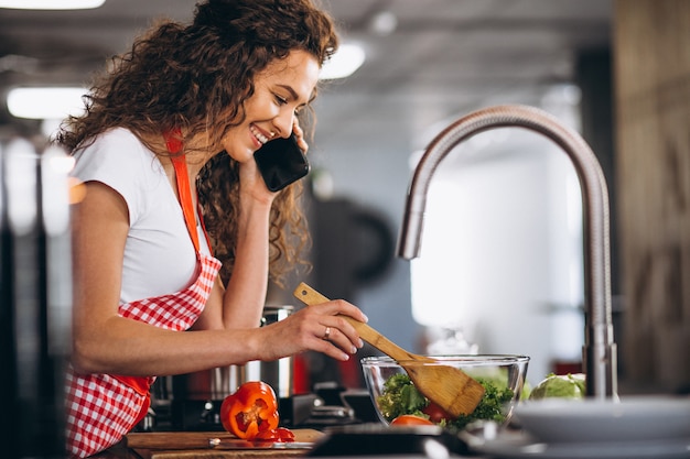 Foto gratuita joven mujer cocinando en la cocina