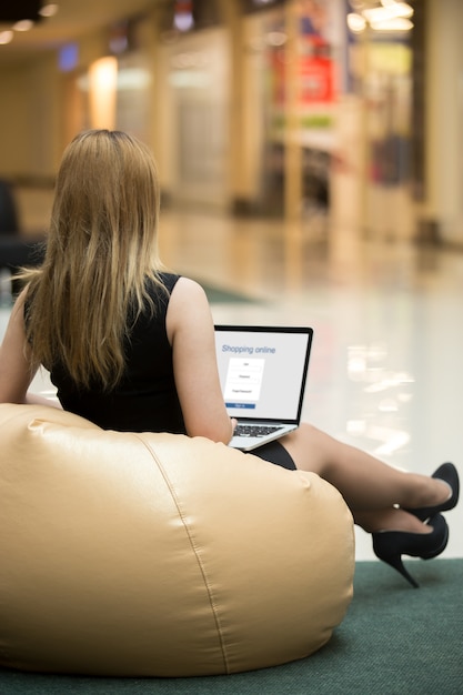 Foto gratuita joven mujer de compras a través de la aplicación electrónica