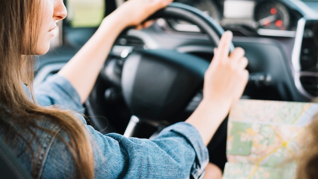 Joven mujer conduciendo coche