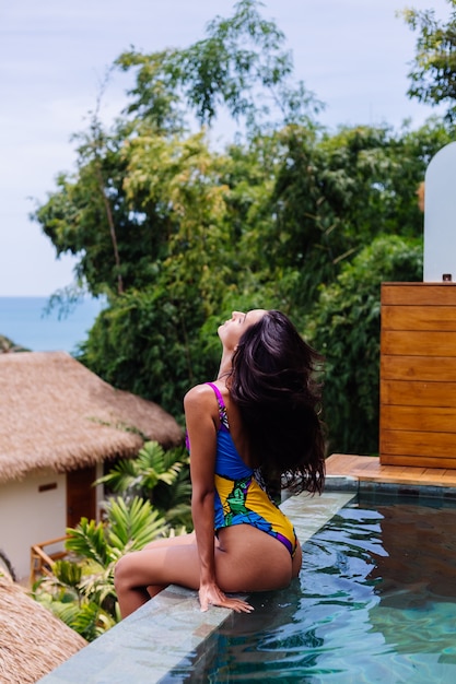 Joven mujer delgada feliz bastante positiva en traje de baño colorido en la villa de lujo increíble hotel disfrutando de un hermoso día de vacaciones en Tailandia