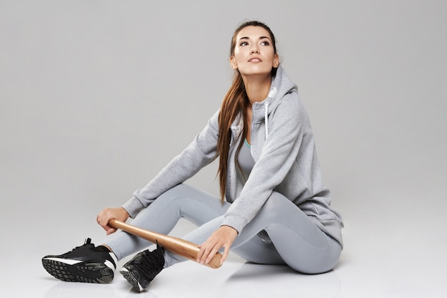 Foto gratuita joven mujer deportiva brutal en ropa deportiva sentado con poco en blanco.