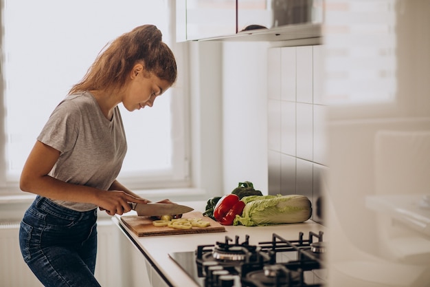 Joven mujer deportiva cocinando en la cocina